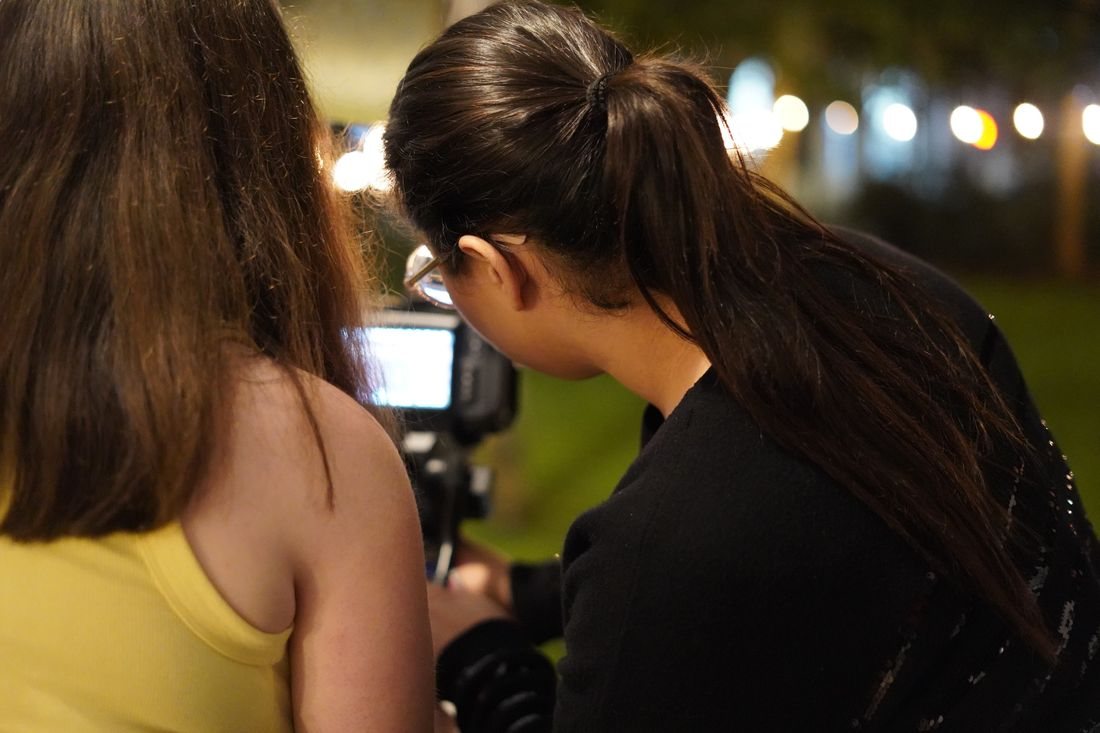 Two crew members check a shot on the camera monitor