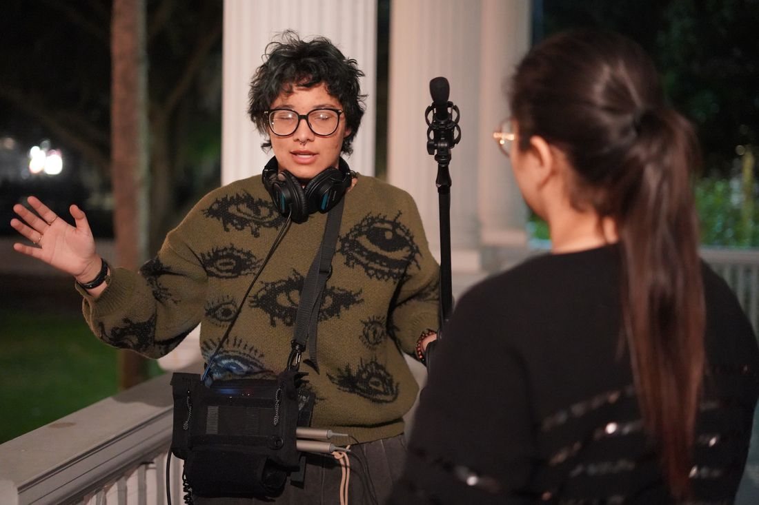 The sound recordist talks with a crew member between takes